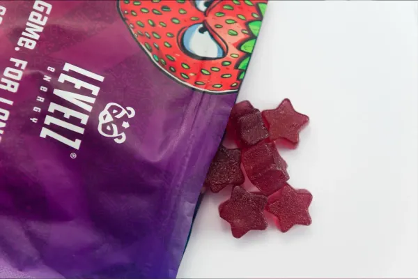 Energy gummies for gaming next to an energy powder tub on a desk